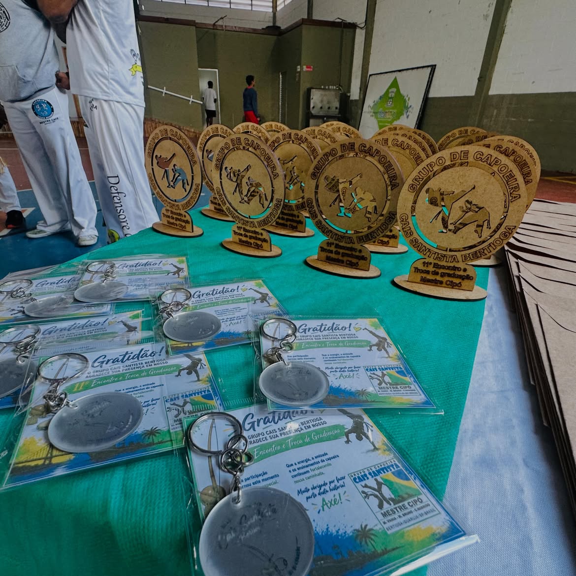 Troféus e lembranças de evento de capoeira sobre mesa